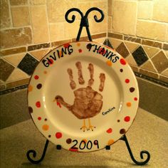 a plate with a handprint on it that says giving thanks