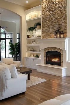 a living room with white furniture and a fireplace