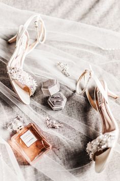 wedding shoes, perfume and jewelry on a veiled tablecloth with the bride's dress