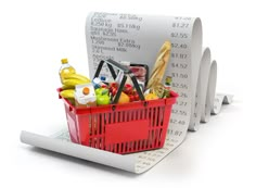 a shopping basket full of groceries sitting on top of a receipt