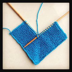 a blue piece of yarn with a wooden knitting needle