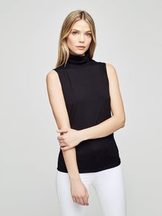 A sleeveless black turtleneck with timeless appeal gets a subtle sheen and smooth finish from a luxe microfiber fabrication. The slim fit compliments denim and is an ideal for base layer Black Fitted Sleeveless Mock Neck Top, Fitted Sleeveless Black Mock Neck Top, Elegant Sleeveless Mock Neck Top For Spring, Elegant Second-skin Fit Tank Top, Chic Black Turtleneck Tank Top, Black Stretch Sleeveless Mock Neck Top, Black Turtleneck Tank Top For Layering, Chic Sleeveless Second-skin Top, Elegant Stretch Tank Top For Fall