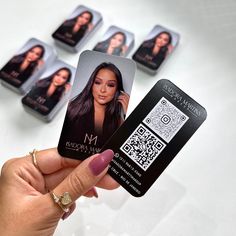 a person holding up a business card with photos on it