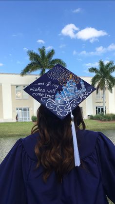 a person wearing a graduation cap with writing on it and palm trees in the background