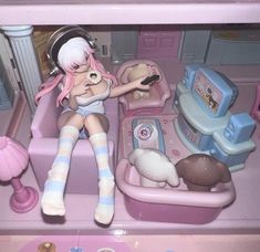 there is a doll that is sitting in a toy car with other toys on the floor