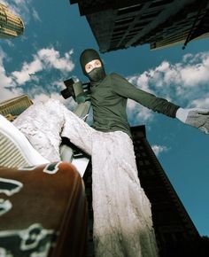 a person wearing a mask standing on top of a building