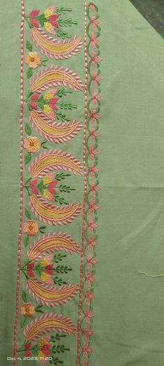 an embroidered green cloth with pink and yellow flowers