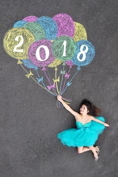 a woman in a blue dress is holding a balloon with the year 2018 written on it