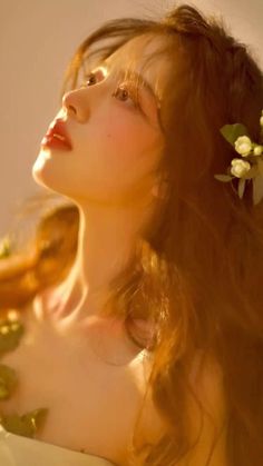 a woman with long hair and flowers in her hair is looking up into the sky