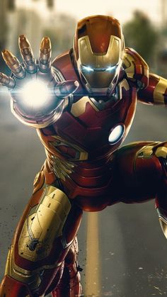 an iron man in the middle of a street with his hands out to light up