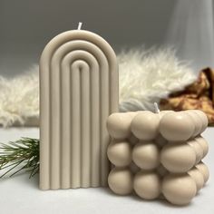 a white candle sitting on top of a table next to a pile of balls