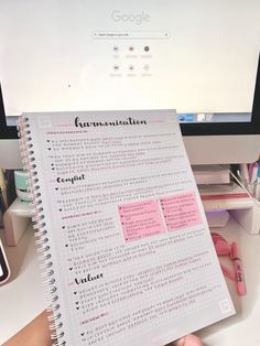 someone is holding up a paper that has been written in japanese on the side of their computer