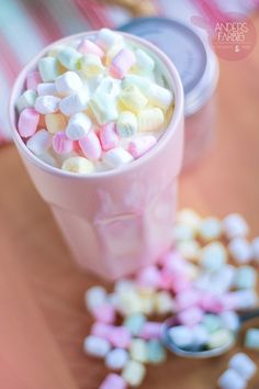 a cup filled with marshmallows on top of a table