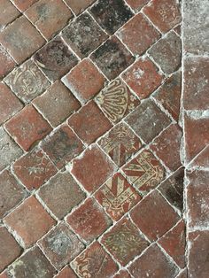 an old brick floor with some designs on it