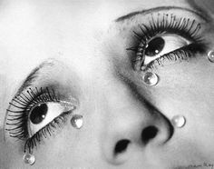 a woman's eye with water drops on her lashes and eyeshade, black and white photograph