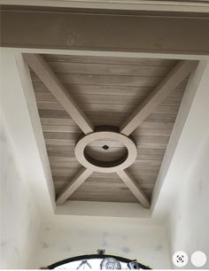 the ceiling in this room is made out of wood and has a circular light fixture