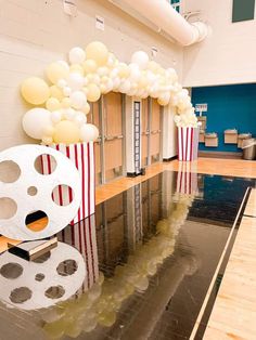 an empty room with balloons and film reels on the floor