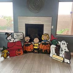 a group of paper cutouts sitting on top of a wooden floor in front of a fireplace