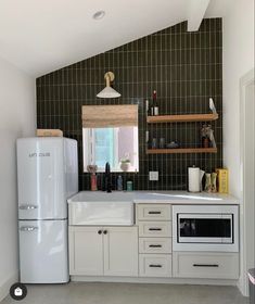 a white refrigerator freezer sitting inside of a kitchen next to a counter top oven