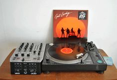 an old record player sitting on top of a wooden table next to a vinyl album