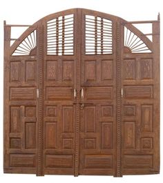 a large wooden gate with intricate carvings on the top and bottom panels, set against a white background