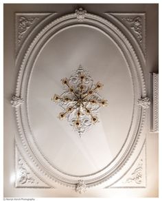 an ornate white ceiling with a snowflake in the center