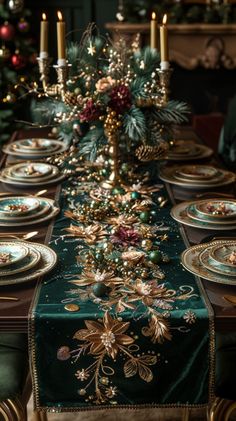 the table is set for christmas dinner with green and gold plates, candles and decorations