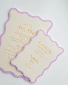 two white and pink menus with gold lettering