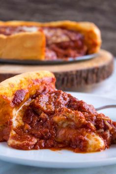 a piece of deep dish pizza on a plate with a fork in front of it