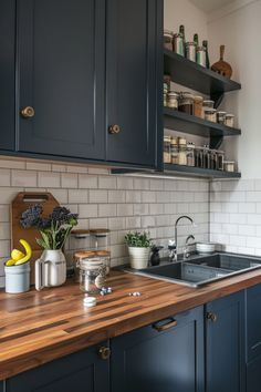 a kitchen with blue cabinets and wooden counter tops, white subway tile backsplash