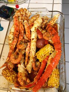 crab legs and corn on the cob in a glass dish