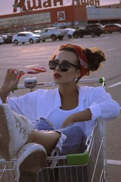 a woman sitting in a shopping cart with her feet up