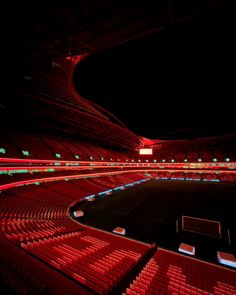 an empty stadium at night with red lights