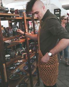 a man standing in front of a shelf filled with plates