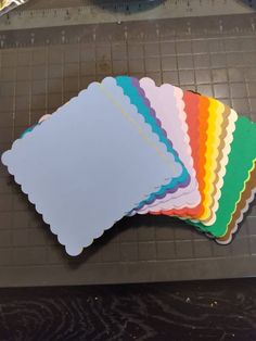 several different colors of paper sitting on top of a table