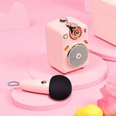 a pink and black speaker sitting on top of a table next to some tulips