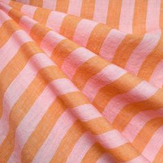 an orange and pink striped fabric with white stripes on it's surface, close up