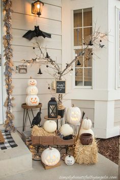 a porch decorated for halloween with pumpkins, hay bales and decorations on it