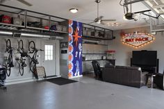 a garage with bikes hanging from the ceiling and a couch in front of it,