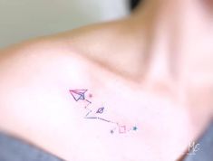 a woman with a small tattoo on her chest that has a paper airplane and stars