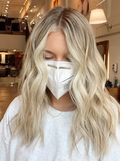 a woman with blonde hair wearing a face mask to protect herself from the corona pandemic