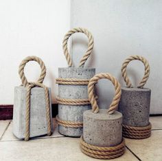 four cement containers with rope wrapped around them