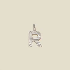 With a playful texture that bounces light, this shimmery letter R hangs straight from the top, adding a classic spark to your style and shine to your story. Specifically designed for versatility, this charm will easily slide over your existing MBM chain or link lock for a uniquely personalized touch. *Please note that no chain is included with this charm. For an included chain, see the Initial Pendant Necklace. Link lock necklace and bracelet sold separately. VIDEO: How to Add Charms to Chain Gold Bar Necklace Personalized, Initial R, Made By Mary, Lock Necklace, Initial Pendant Necklace, Pearl Cluster, Letter R, Necklace And Bracelet, Personalized Initials