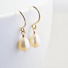 "White pearl earrings. Gold filled earrings featuring lustrous 7mm white freshwater teardrop shaped pearls handpicked to match as perfect as possible. They hang from handcrafted gold filled ear wires I created especially for these pearls. Perfect for everyday wear! Length from top of ear wire is slightly under 1\". Variations: Sterling silver Gold fill Rose gold fill Complimentary Gift Wrap! Not quite what you are looking for? Other earrings available: Studs: http://etsy.me/1zWKO9Q Earrings: htt Handmade Classic Pear-shaped Pearl Earrings, Classic Handmade Pear-shaped Pearl Earrings, Classic Pearl Teardrop Dangle Earrings, Classic Pearl White Teardrop (pear Shaped) Earrings, Classic Pearl Teardrop Earrings, Classic Teardrop Pearl White Earrings, Classic Pearl White Pear-shaped Teardrop Earrings, Teardrop Pearl Charm Earrings For Anniversary, Pearl Drop Earrings Gift