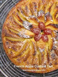 french apple custard tart with powdered sugar and strawberries on top