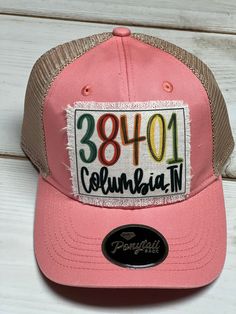 a pink trucker hat with an embroidered patch on the front that says, 3810 columbia