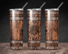 three wooden tumblers with engraved images on them, one has a straw in it