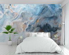 a bed sitting in a bedroom next to a large painting on the side of a wall