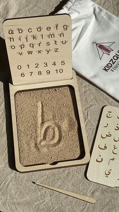 a wooden box with some type of writing on it next to a pair of scissors