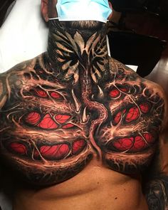 a man's chest covered in tattoos with red and black designs